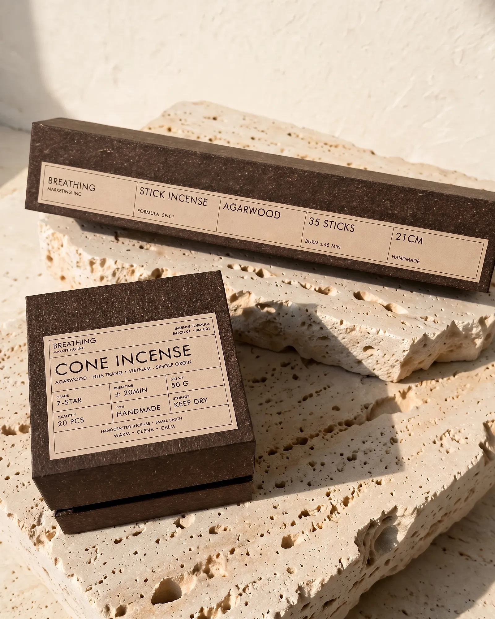 Two incense boxes, a long box for sticks and a square box for cones, on travertine