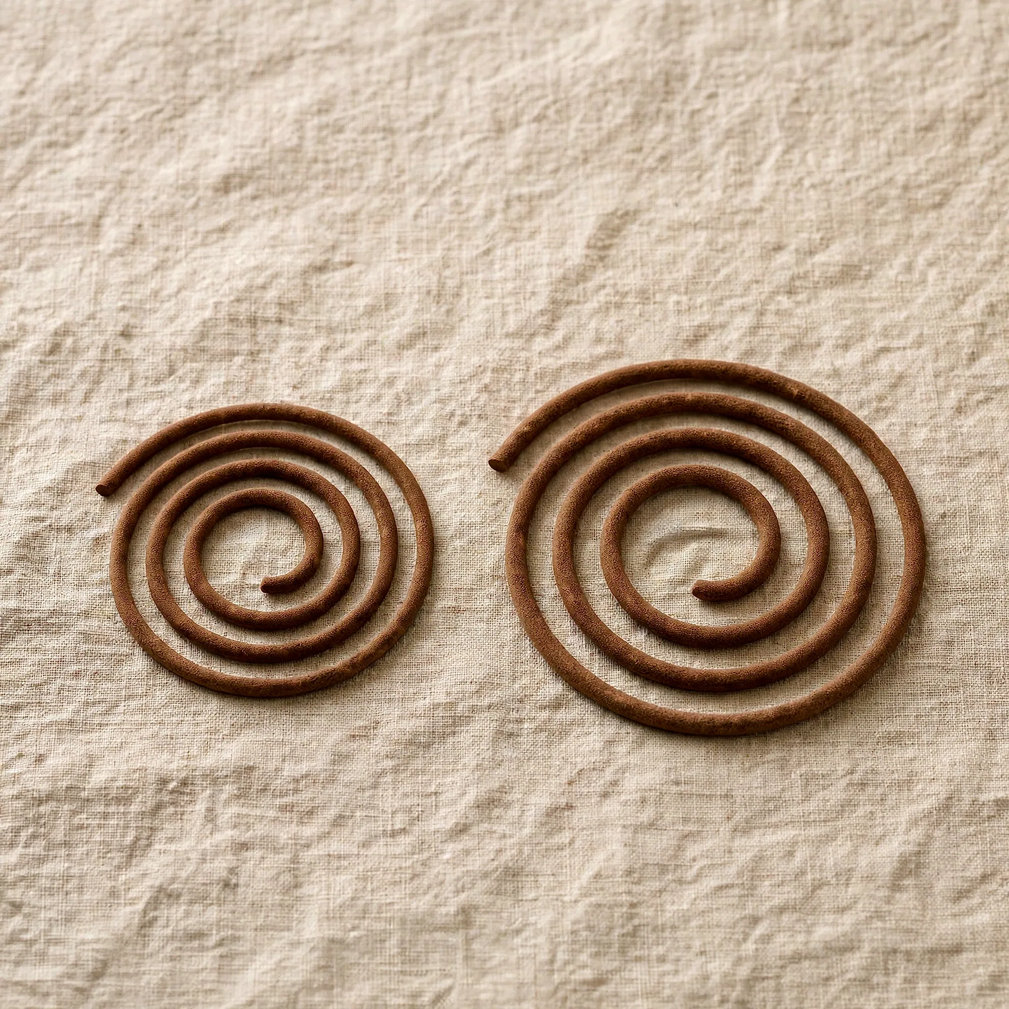 Two incense coils side by side, the 2-hour and the slightly larger 4-hour